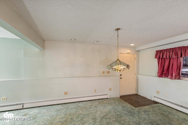 carpeted spare room with a baseboard radiator and a textured ceiling