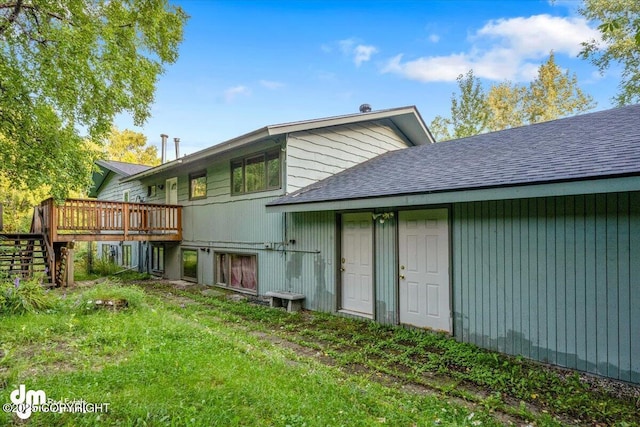 back of house with a deck, a shingled roof, and stairs