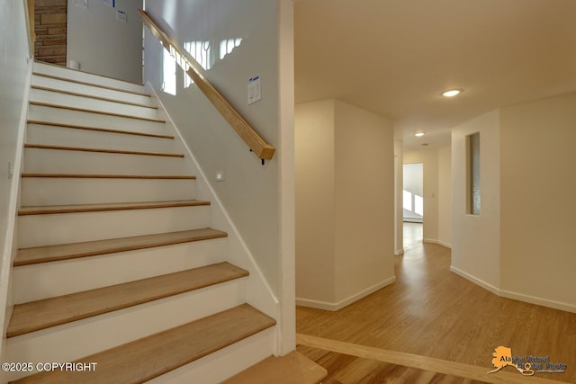 staircase with baseboards, wood finished floors, and recessed lighting