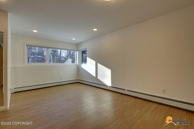 unfurnished living room with a baseboard heating unit, wood finished floors, and recessed lighting