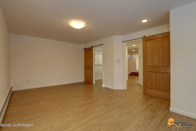 unfurnished room featuring a barn door, a baseboard heating unit, light wood finished floors, baseboards, and recessed lighting