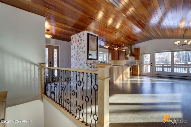 staircase with vaulted ceiling, a chandelier, hardwood / wood-style floors, wooden ceiling, and a baseboard radiator