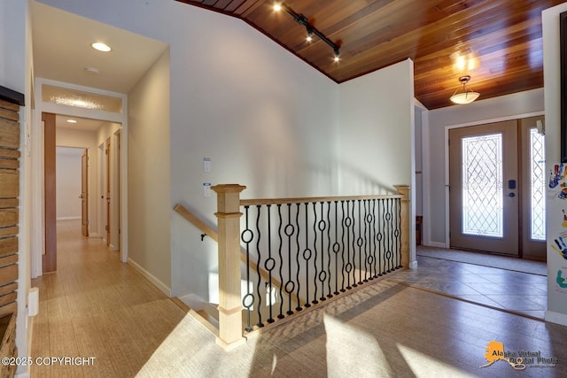 entrance foyer with wood ceiling, vaulted ceiling, and baseboards