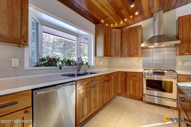 kitchen with wall chimney range hood, a sink, stainless steel appliances, light countertops, and backsplash