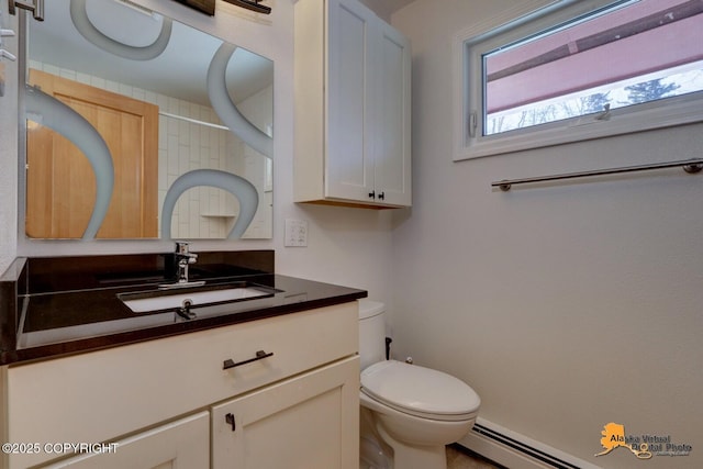 half bathroom with a baseboard heating unit, vanity, and toilet