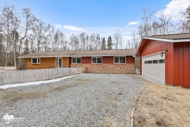 single story home featuring an attached garage, driveway, and fence