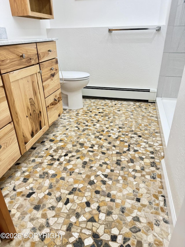 full bath with a baseboard radiator, toilet, and vanity