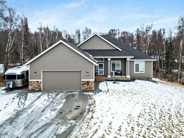 view of front of house with stone siding, covered porch, and an attached garage