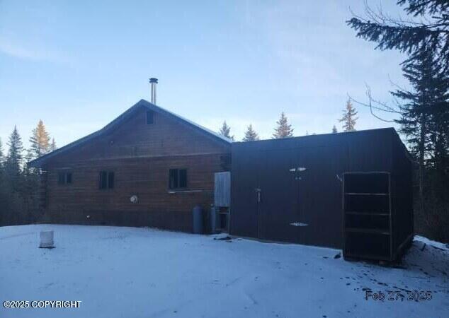 view of snow covered back of property