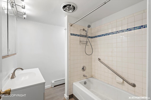 521 N St, Anchorage, AK 99501 - full bath featuring visible vents, wood finished floors, vanity, a baseboard heating unit, and shower / bathtub combination