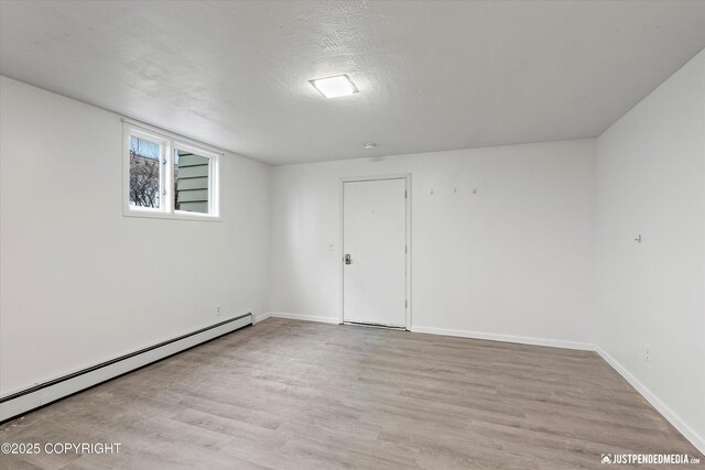 521 N St, Anchorage, AK 99501 - unfurnished room featuring baseboards, a textured ceiling, wood finished floors, and a baseboard radiator