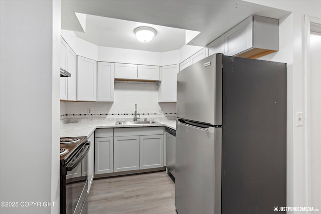 521 N St, Anchorage, AK 99501 - kitchen with light countertops, tasteful backsplash, stainless steel appliances, a sink, and light wood-style flooring