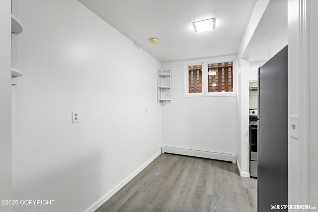 521 N St, Anchorage, AK 99501 - hallway featuring baseboards, a baseboard heating unit, and wood finished floors