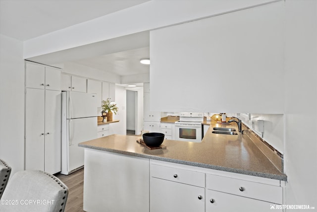 521 N St, Anchorage, AK 99501 - kitchen with white cabinets, a sink, a peninsula, and white appliances