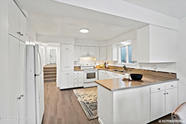 521 N St, Anchorage, AK 99501 - kitchen with a sink, a peninsula, white appliances, white cabinets, and light wood-style floors