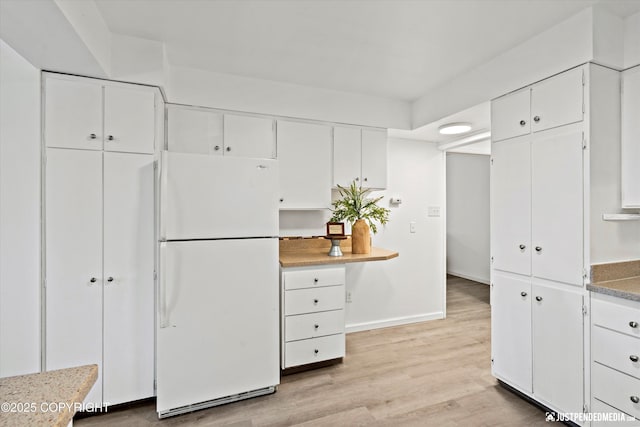 521 N St, Anchorage, AK 99501 - kitchen featuring freestanding refrigerator, white cabinetry, baseboards, and light wood-type flooring