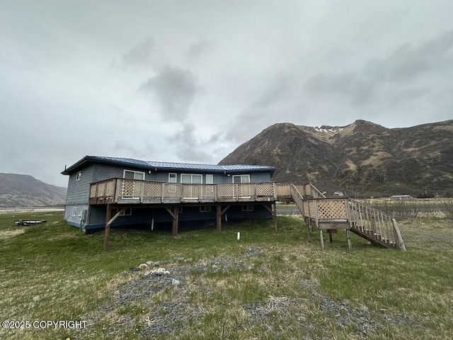 exterior space featuring stairway, a yard, and a deck with mountain view