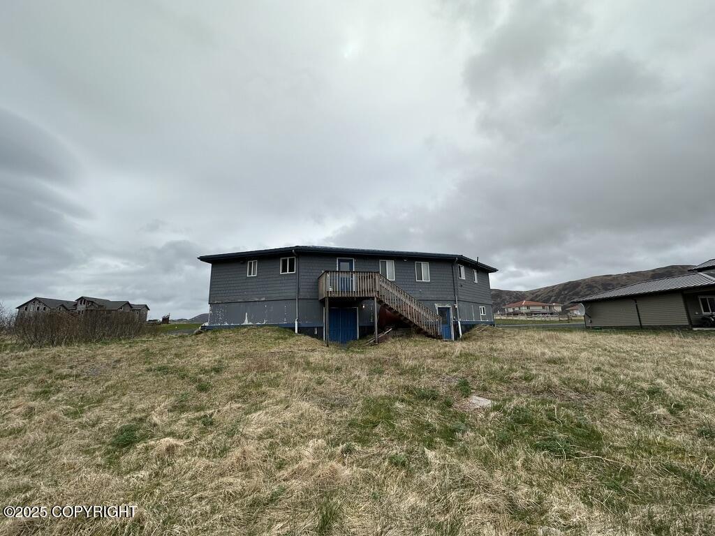 back of house featuring stairs and a deck