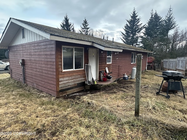 exterior space featuring board and batten siding and fence