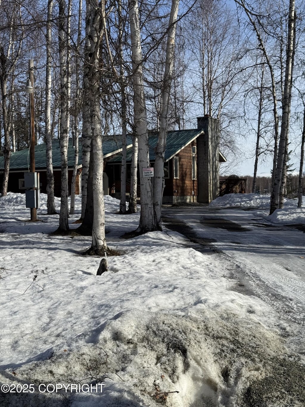 view of front of property featuring driveway and a chimney