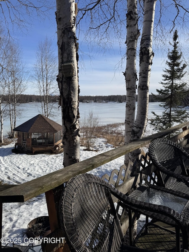 snow covered deck featuring a water view