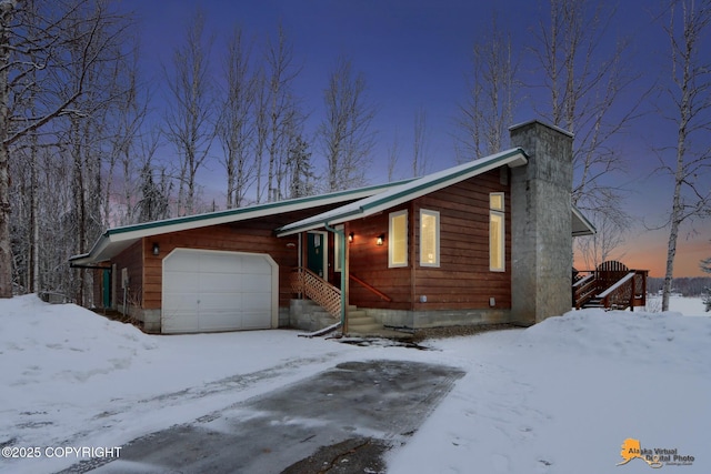 rustic home featuring a garage and a chimney