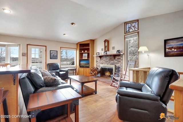 living area featuring light wood finished floors, recessed lighting, a fireplace, and lofted ceiling