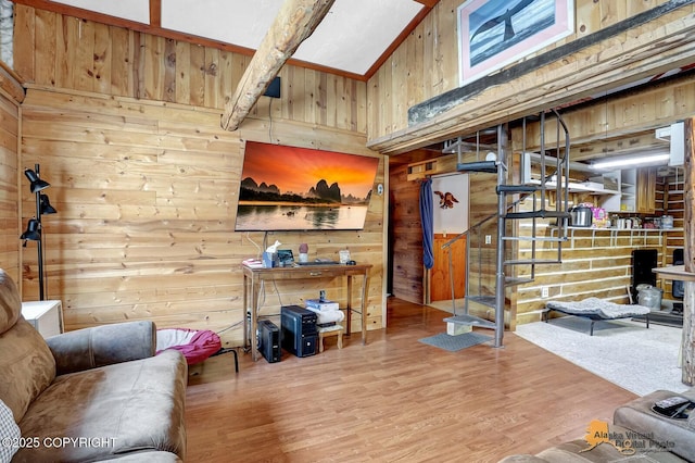 living area featuring wood walls, stairway, and wood finished floors