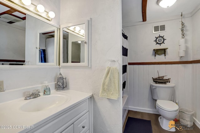 full bath featuring toilet, wood finished floors, vanity, and visible vents