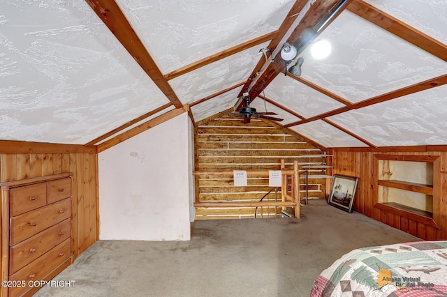 interior space featuring lofted ceiling with beams, wood walls, and a textured ceiling