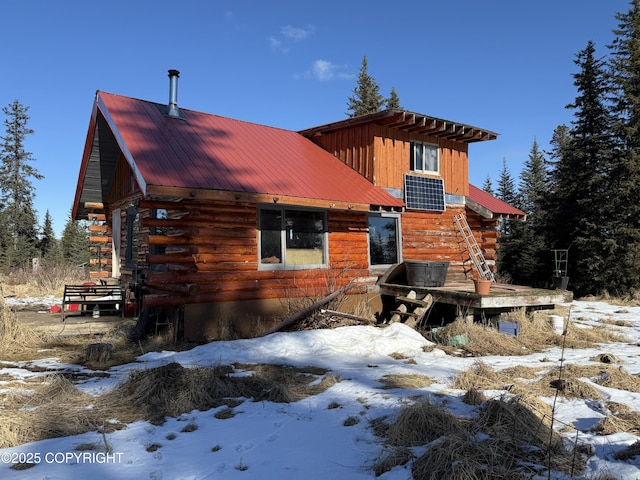 log cabin with metal roof, central AC unit, and log exterior