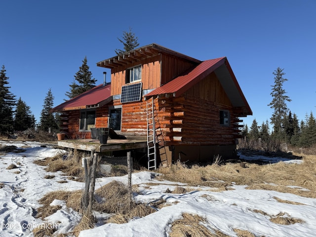 view of front of home with log siding and metal roof