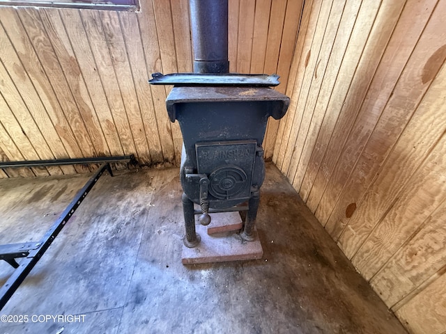 interior details with wooden walls and a wood stove