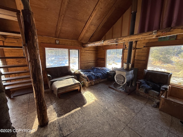 bedroom with high vaulted ceiling, wood walls, and a wood stove