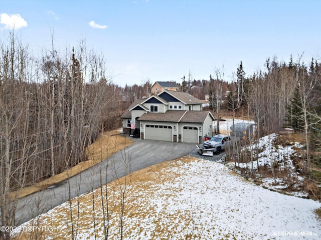 view of front of home featuring aphalt driveway, a garage, and roof with shingles