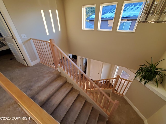 stairs featuring a healthy amount of sunlight, carpet, and baseboards