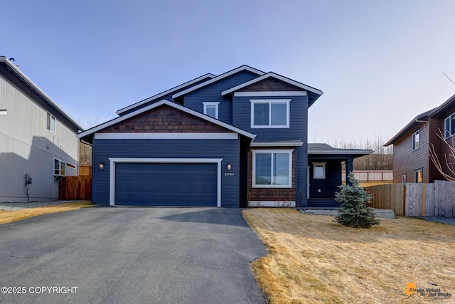 craftsman-style house featuring aphalt driveway, fence, and a garage