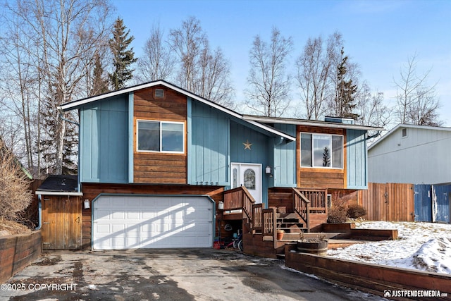 view of front of house with driveway, an attached garage, and fence