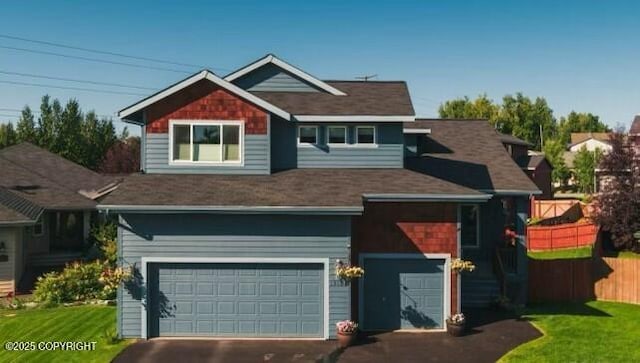 view of front of home featuring aphalt driveway, a front lawn, an attached garage, and fence