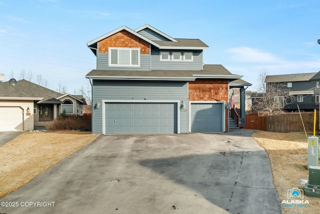 view of front of home featuring an attached garage, fence, and driveway