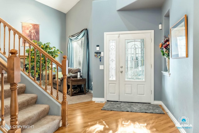 entryway with stairway, baseboards, and wood finished floors