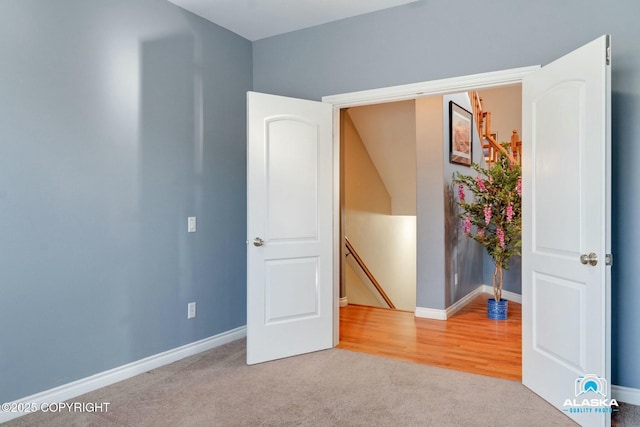 carpeted empty room featuring baseboards