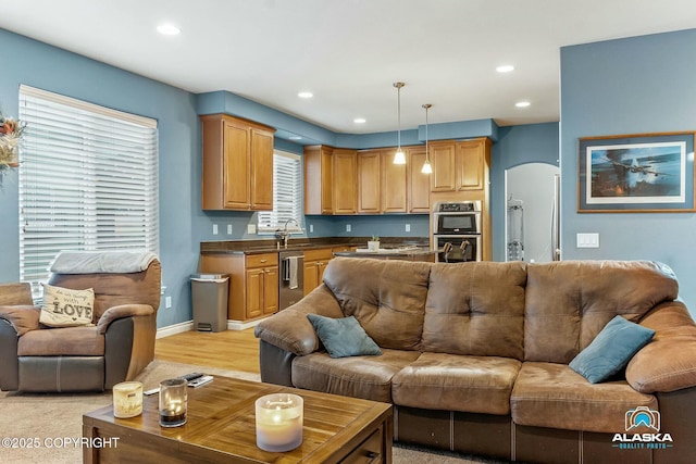 living room featuring recessed lighting, baseboards, and arched walkways