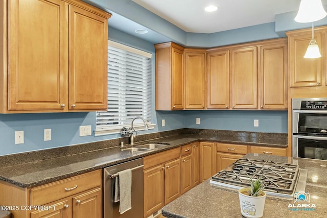 kitchen featuring a sink, decorative light fixtures, appliances with stainless steel finishes, and dark stone countertops