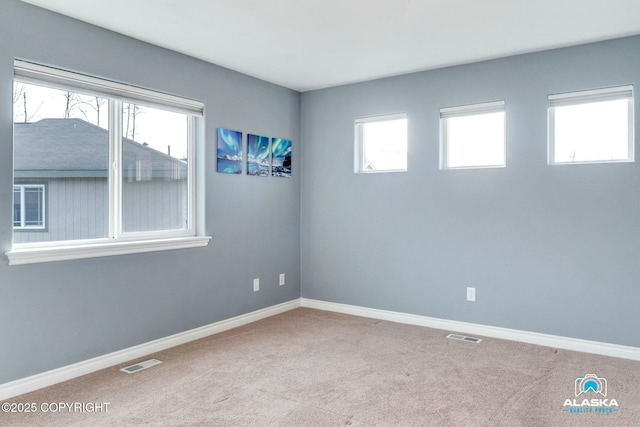 unfurnished room with visible vents, baseboards, and carpet floors