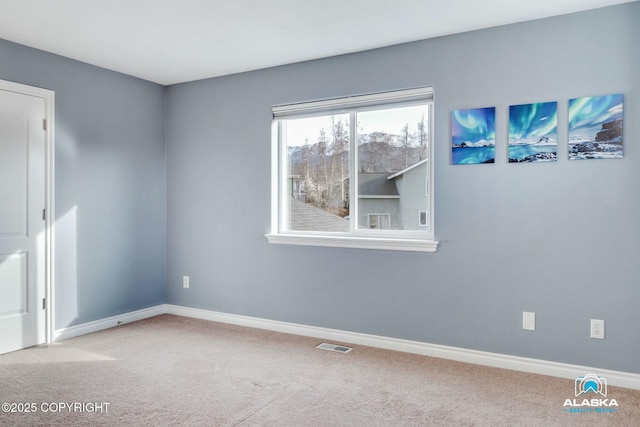 empty room with visible vents, carpet floors, and baseboards