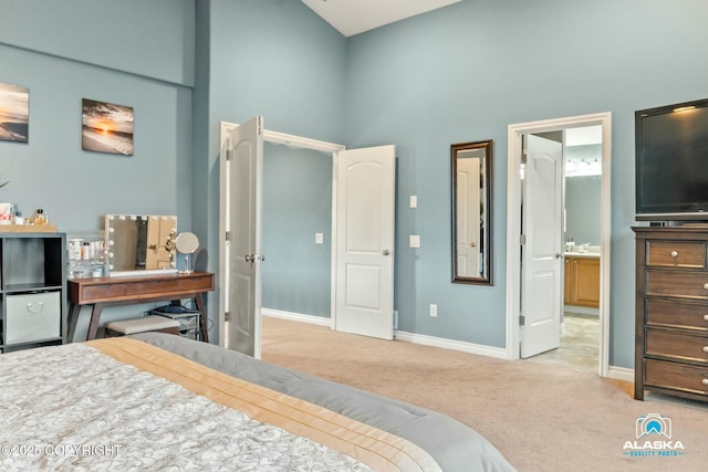 bedroom featuring carpet flooring, ensuite bath, a high ceiling, and baseboards