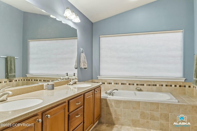 full bathroom featuring vaulted ceiling, a garden tub, double vanity, and a sink