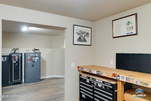 home office with light wood-style flooring and baseboards