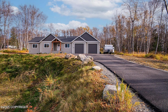 ranch-style house featuring aphalt driveway and an attached garage